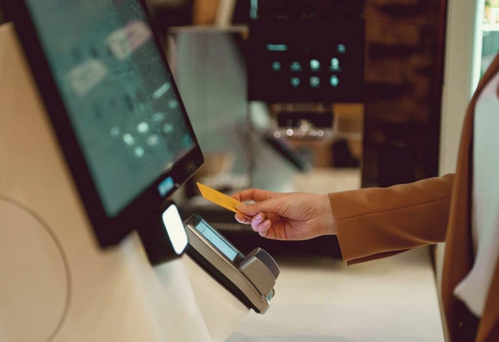 Customer completing an order at a self-service kiosk in a quick-service restaurant