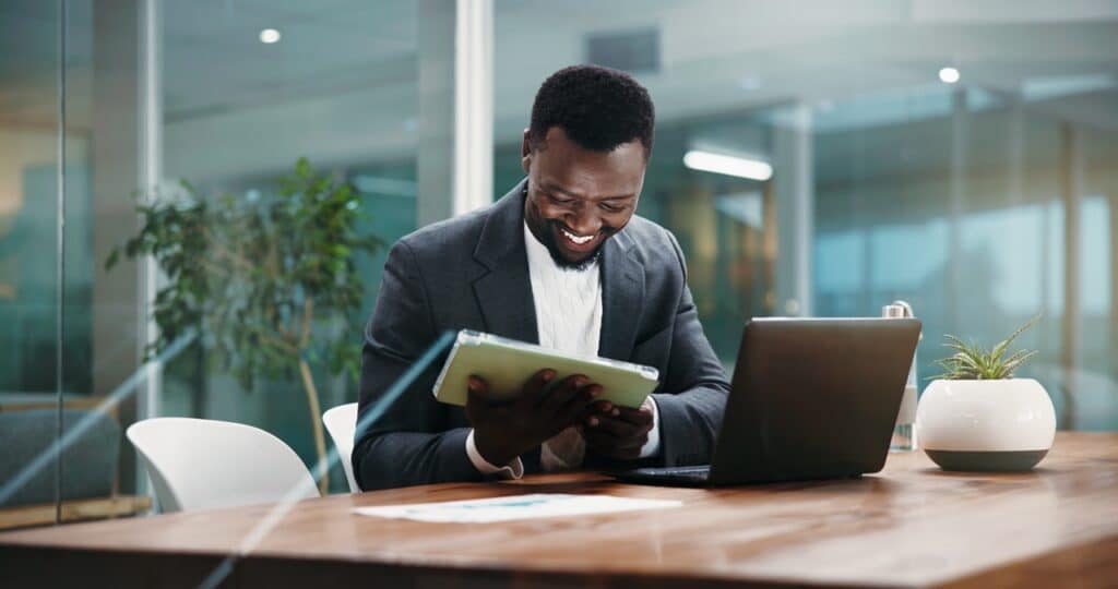 Operations manager reviewing kiosk device health monitoring on a tablet at his desk