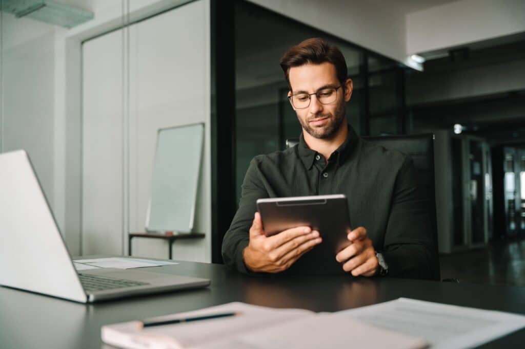 IT administrator configuring iOS supervised mode on an iPad in a modern office